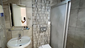 Un baño con lavabo, inodoro y espejo.