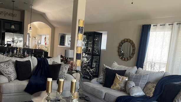 A modern living room with a grey sofa set, a glass coffee table, and a ceiling fan. - Charming Crowley Rental (Crowley)