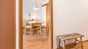 Een eethoek met een ronde houten tafel, vier stoelen en een hanglamp.