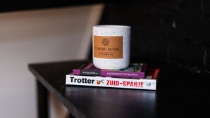 A white mug with a label on a stack of books.