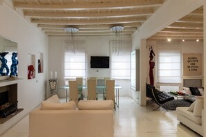 Un amplio salón con una mesa de comedor, sofás y televisor.