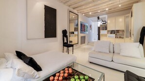 A modern living room with a glass coffee table, white sofas, and a large abstract painting. - The Borgias were here! Charming and modern, by Campo de’ Fiori (Roma)