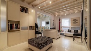 A modern living room with white furniture, a zebra-patterned ottoman, and a bookshelf. - The Borgias were here! Charming and modern, by Campo de’ Fiori (Roma)