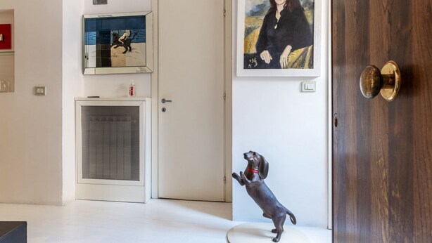 A modern interior with a dog statue, a door, and a framed portrait on the wall. - The Borgias were here! Charming and modern, by Campo de’ Fiori (Roma)