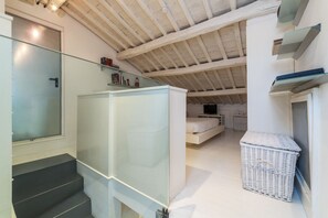 A modern interior with a staircase, a white wardrobe, a glass door, and a wicker basket. - The Borgias were here! Charming and modern, by Campo de’ Fiori (Roma)