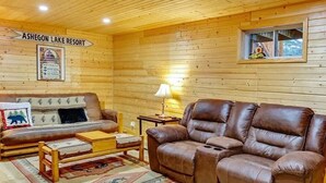 A wooden cabin interior with a brown leather sofa, a wooden coffee table, and a rug. - Spacious 3 Story Cabin. Access to UTV/ATV Trails & Near Lake Arbutus (Merrillan)