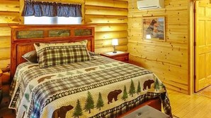 A cozy log cabin bedroom with a wooden bed, a ceiling fan, and a window with curtains. - Spacious 3 Story Cabin. Access to UTV/ATV Trails & Near Lake Arbutus (Merrillan)