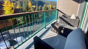 Ein Balkon mit Korbmöbeln und Blick auf eine Berglandschaft.