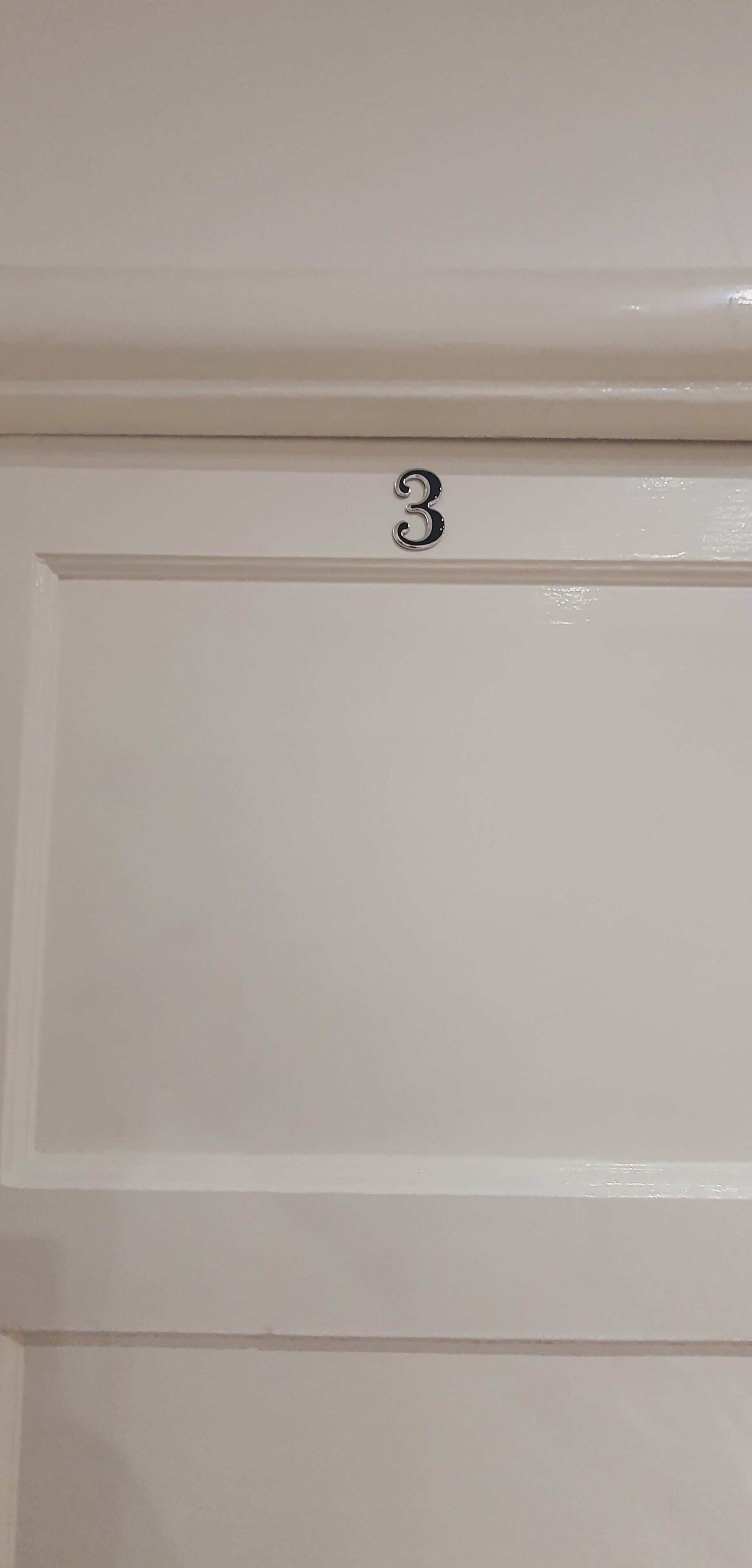 A white door with a number "3" above it.