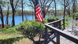 A wooden deck with a view of a lake and trees.