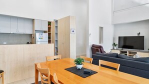A modern apartment with a kitchen, dining area, and living room.