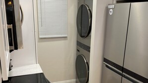 Una cocina moderna con tope de inducción negro, electrodomésticos de acero inoxidable y horno empotrado.