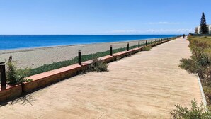 Une promenade en bord de mer offrant une vue dégagée sur la plage et l’océan.