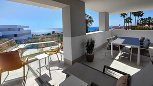 Un balcon doté d’un espace repas, d’un coin salon et offrant une vue sur l’océan.