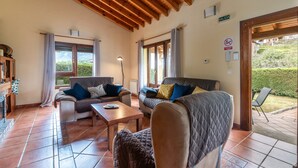 Una sala de estar acogedora con dos sofás, una mesa de centro y techo de madera.