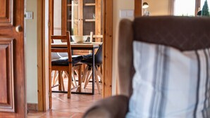 Un comedor con una mesa y sillas de madera, un cuenco y una lámpara.