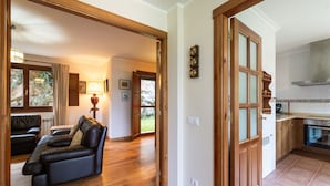 Un vaste espace de vie doté d’un canapé en cuir, de parquet et offrant une vue sur l’extérieur.