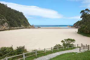 Ein Strand mit einer Holzlattenveranda und einem Kiesweg, der zum Ufer führt.