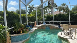 Ein Poolbereich mit Whirlpool, Liegestühlen und einer Delfinstatue.