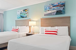 A hotel room with two beds, a nightstand with a lamp, and two paintings of boats on the wall. - Schooner At Compass Cove 243 (Myrtle Beach)