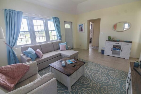 A living room with a sofa, coffee table, and a cabinet.