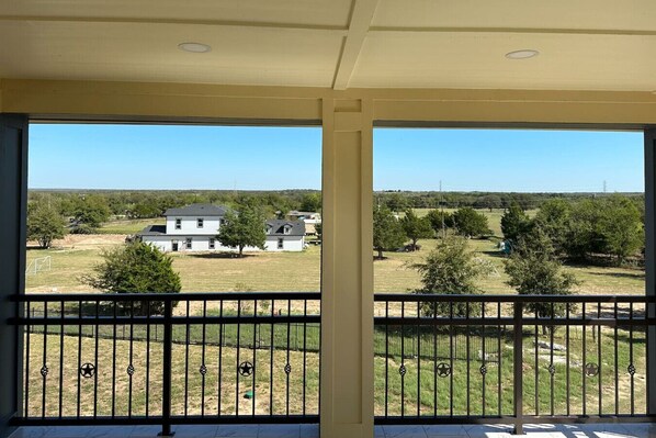 A balcony with a view of a house and surrounding landscape. - Luxury 3-Story Escape ⢠Private Pool ⢠8BR Retreat (Red Rock)