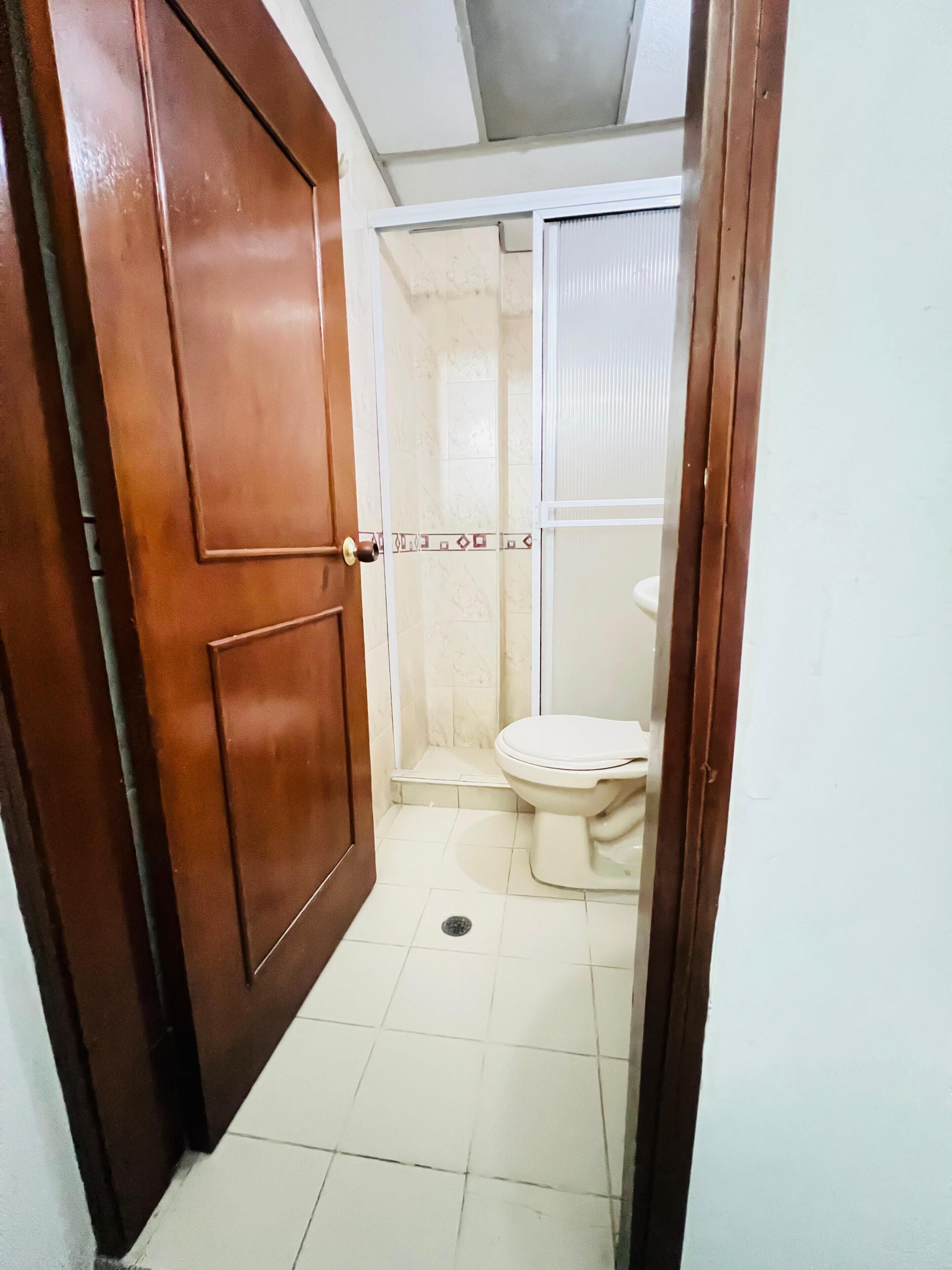 Un baño con inodoro, ducha y puerta.
