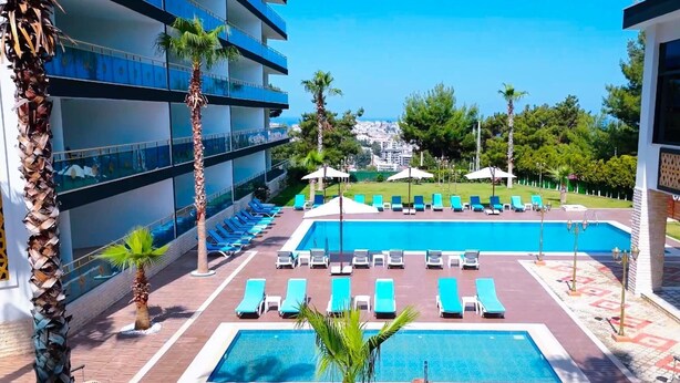 A hotel pool area with multiple lounge chairs and a central swimming pool. - Si Hotel & Spa (Kuşadası)
