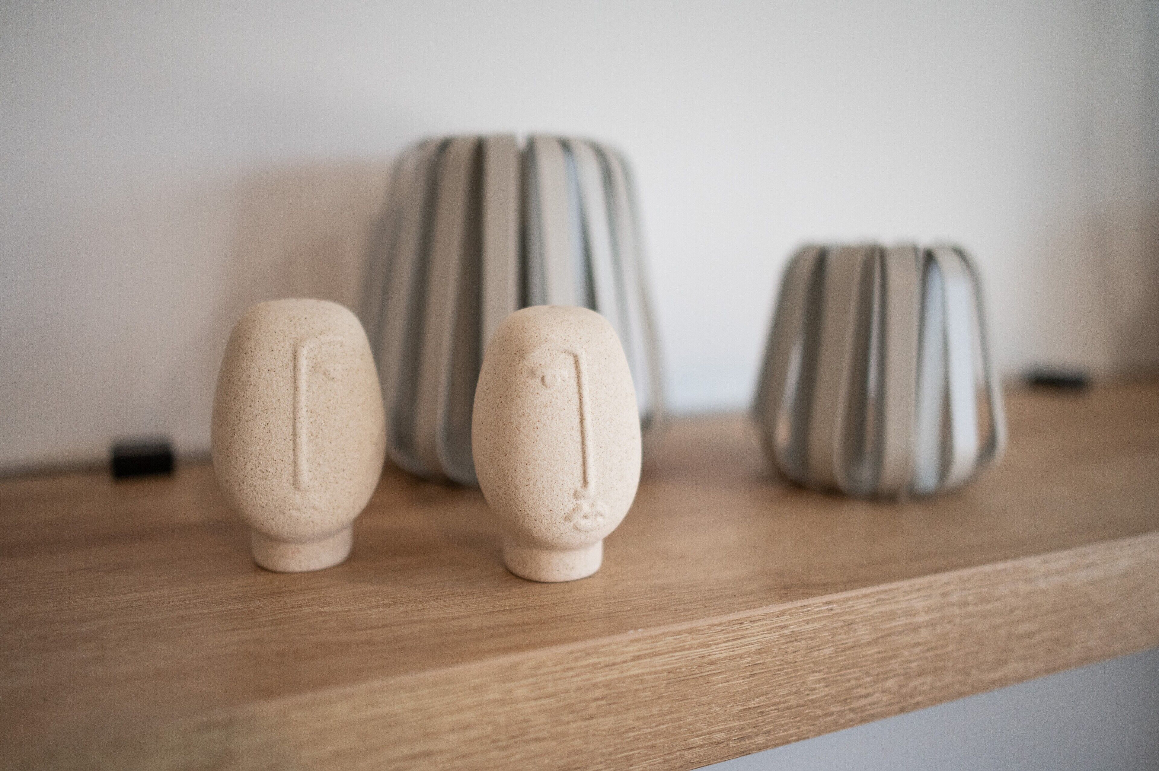 Trois vases en céramique sur une étagère en bois.