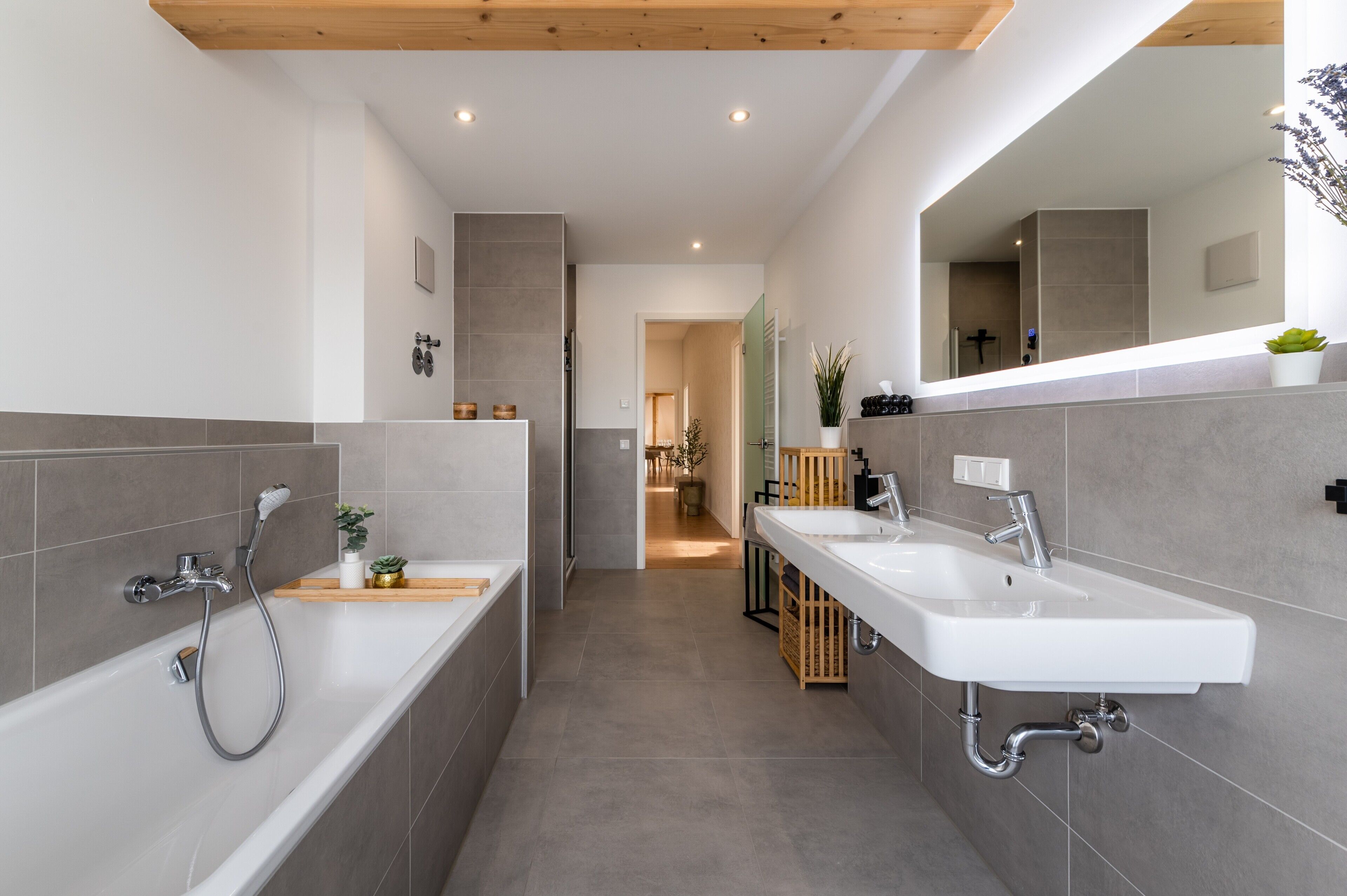 Ein modernes Badezimmer mit zwei Waschbecken, einer Dusche und einem Spiegel.