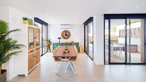 Un espace repas moderne avec une table en bois, des chaises et une horloge au mur.
