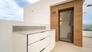 Une salle de bain moderne avec un mur d’accent en bois, une douche et une vue sur la ville.