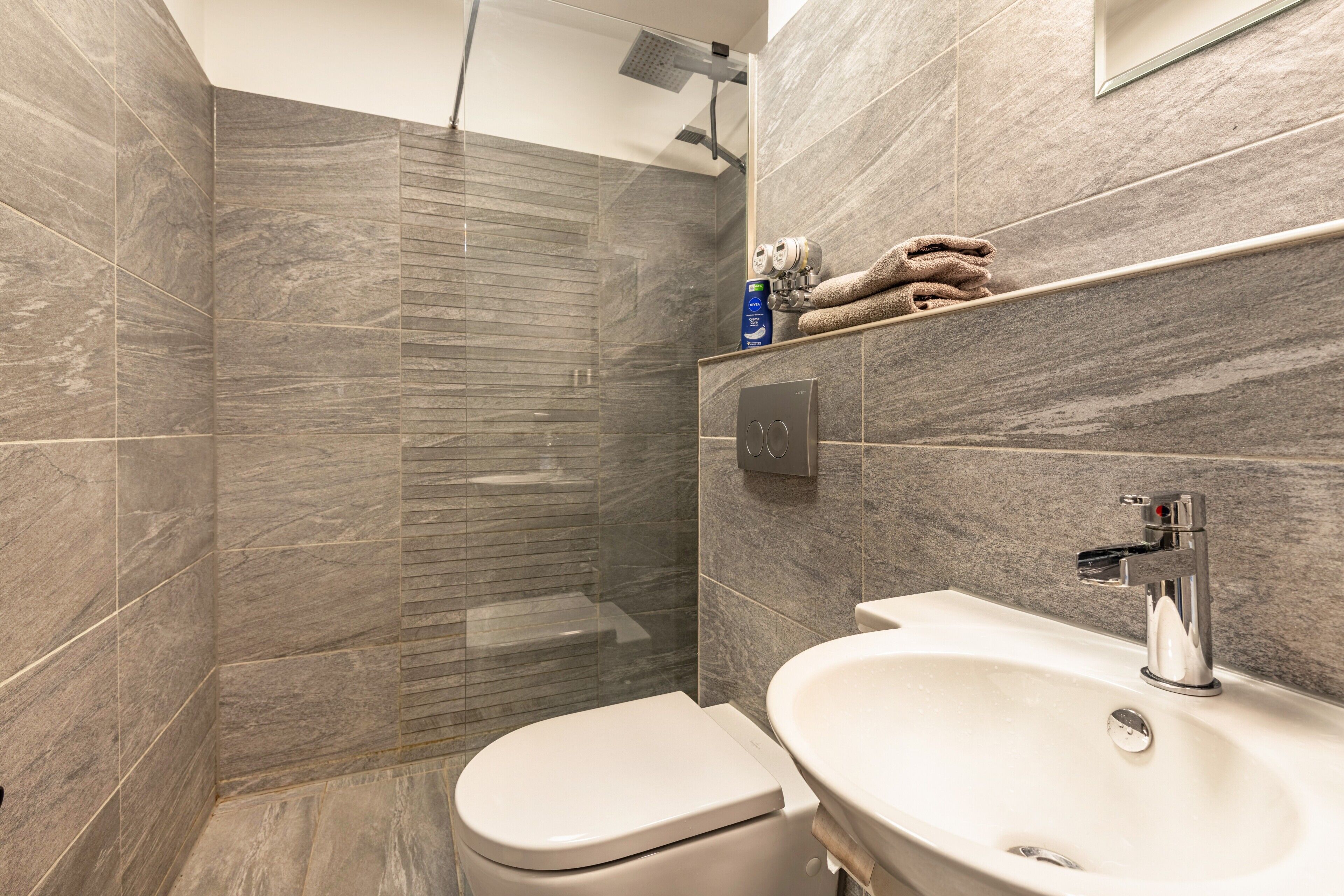 Een douche, een haardroger, handdoeken, toiletpapier