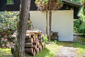 A stack of logs, a tree, and a building with a white exterior. - Holiday Home 'Ferienhaus Sonnenplatz Am See' with Private Terrace (Roding)