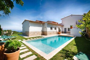 Une maison avec une piscine, des escaliers en pierre et une vue sur la mer.