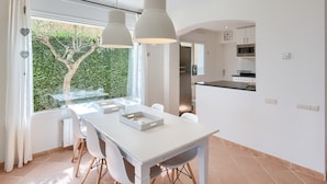 Une cuisine moderne équipée d’un four à micro-ondes, d’un petit réfrigérateur et d’un coin repas avec une table et des chaises.