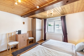 A bedroom with two beds, a wooden desk, a chair, and a window with curtains. - Holiday Apartment 'Gästehaus Gross' with Private Terrace, Garden, and Wi-Fi (Neustadt an der Weinstraße)