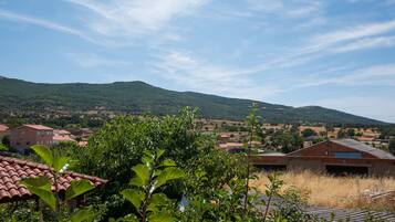 Un paisaje rural con casas, follaje y colinas.