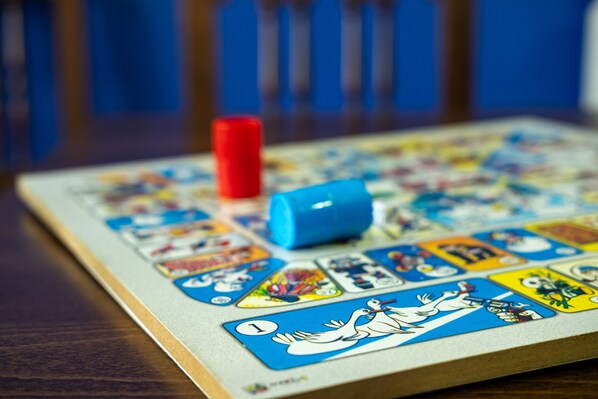 Un juego de mesa con varias cartas y fichas de colores sobre una mesa de madera.
