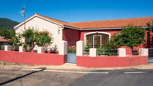 A building with a red facade, a tiled roof, and a gated entrance. - Holiday Home 'El Parral' with Mountain Views, Shared Terrace and Wi-Fi (La Rinconada de la Sierra)