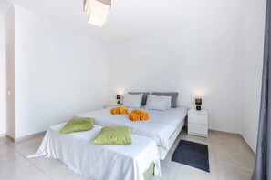 A bedroom with a bed, two nightstands, a bedside lamp, and a rug. - Apartment 'Casa Cláudia - Centro Histórico' with Private Terrace, Balcony and Wi-Fi (Lagos)