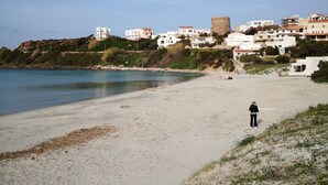 Eine Küstenstadt mit Gebäuden, einem Strand und einer burgähnlichen Struktur.