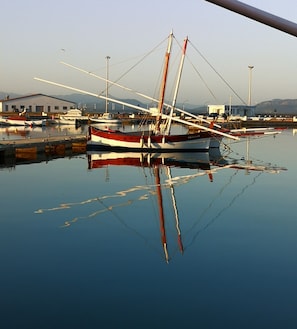 Puerto deportivo con varias embarcaciones amarradas, agua tranquila y cielo despejado.
