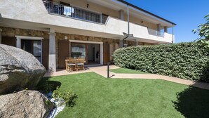 A two-story building with a balcony, a stone facade, and a well-maintained lawn. - Apartment 'Flat Arcipelago' with Shared Pool, Wi-Fi and Air Conditioning (Palau)
