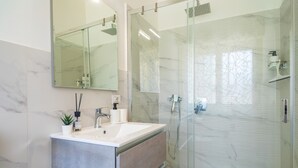 A modern bathroom with a glass-enclosed shower, a marble-tiled wall, and a large mirror. - Apartment 'Al Nitta 2' with Wi-Fi and Air Conditioning (Catania)