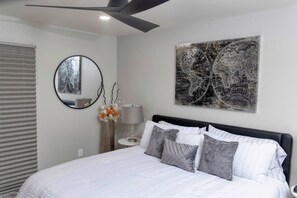 A bedroom with a bed, a round mirror, a lamp, and a world map artwork on the wall. - Sultry Sedona Getaway  (Sedona)