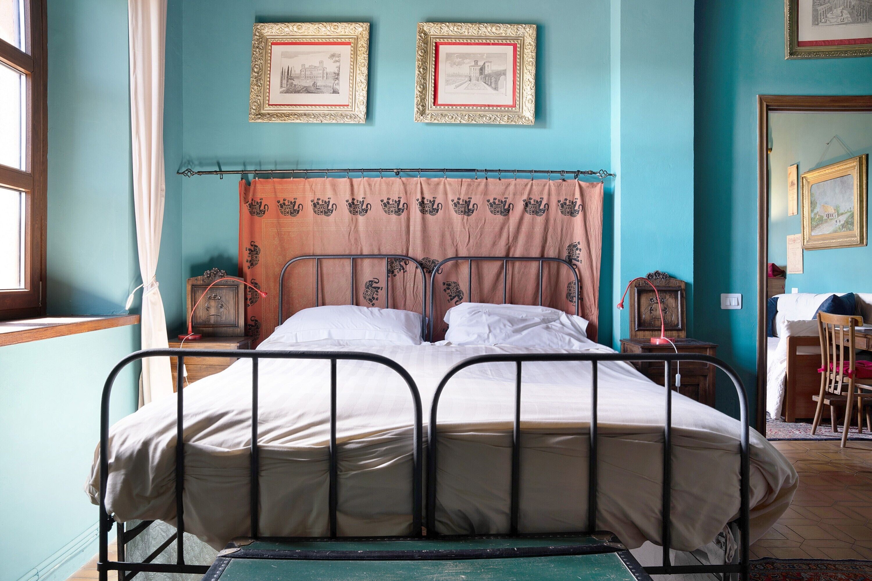 Een kamer met een bed, een raam en een deur.