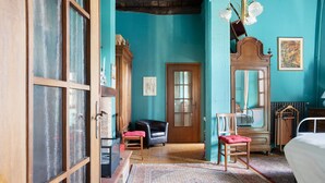 A room with a large mirror, a bed, a wooden wardrobe, and a chair. - Apartment 'Il Flauto Magico' with Mountain View, Shared Garden and Wi-Fi (Serralunga d'Alba)