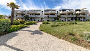 A multi-story hotel with balconies, a gravel pathway, and well-maintained greenery. - Apartment 'Le Rêve 210' with Shared Pool, Wi-Fi, and Air Conditioning (La Tranche-sur-Mer)