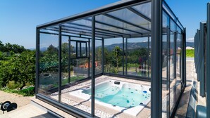 Un jacuzzi entouré de parois de verre offrant une vue dégagée sur le paysage environnant.